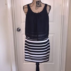 Black and white striped dress with slit in back .